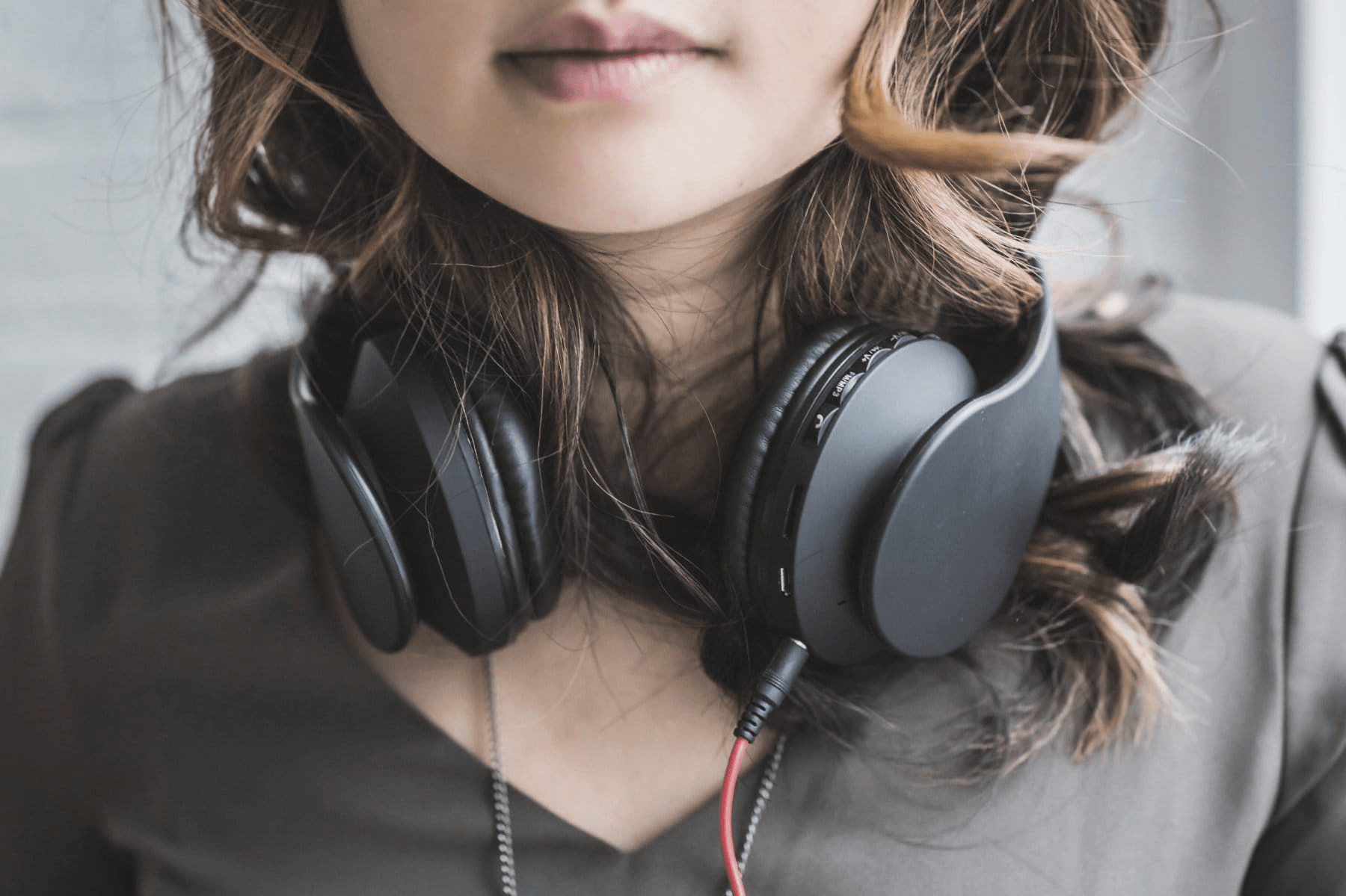 Young woman wearing headphones around her neck.